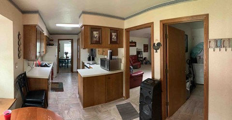 a kitchen and living room with a table and a refrigerator