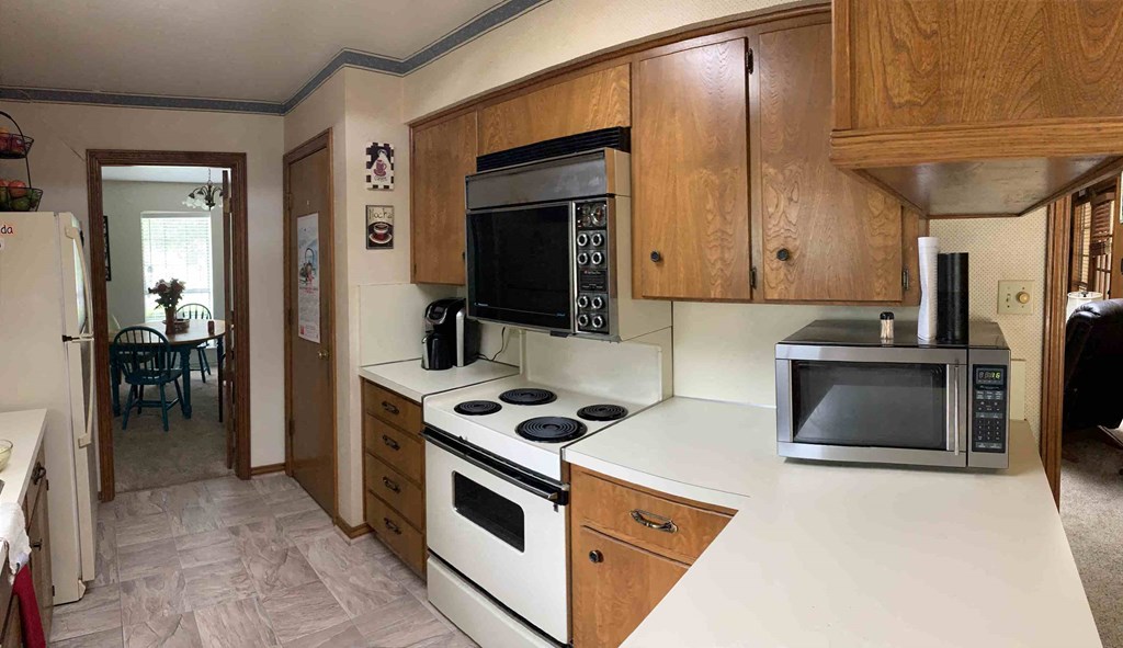 a kitchen with a stove top microwave and a sink