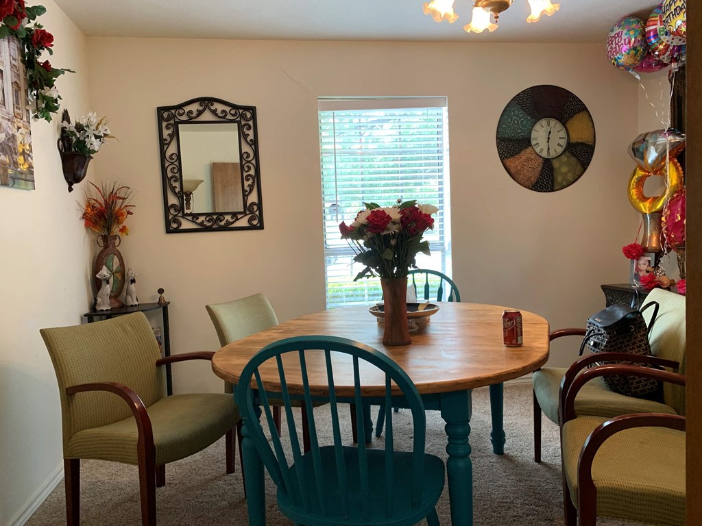 a dining room with a table and chairs and a window