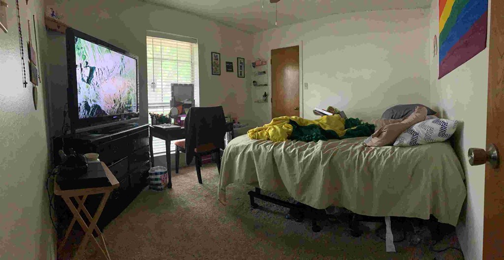 a person laying on a bed watching tv in a bedroom