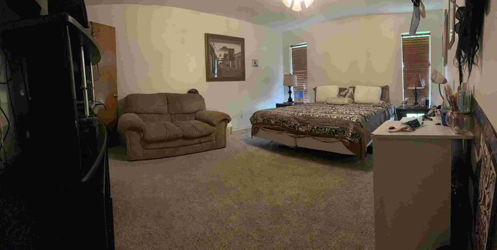 a bedroom with a bed and a couch and a chair