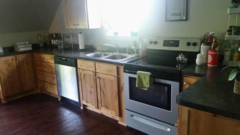 A kitchen with wooden cabinets and a black countertop.