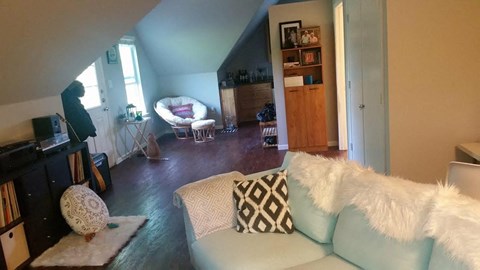A living room with a white couch and a white chair.