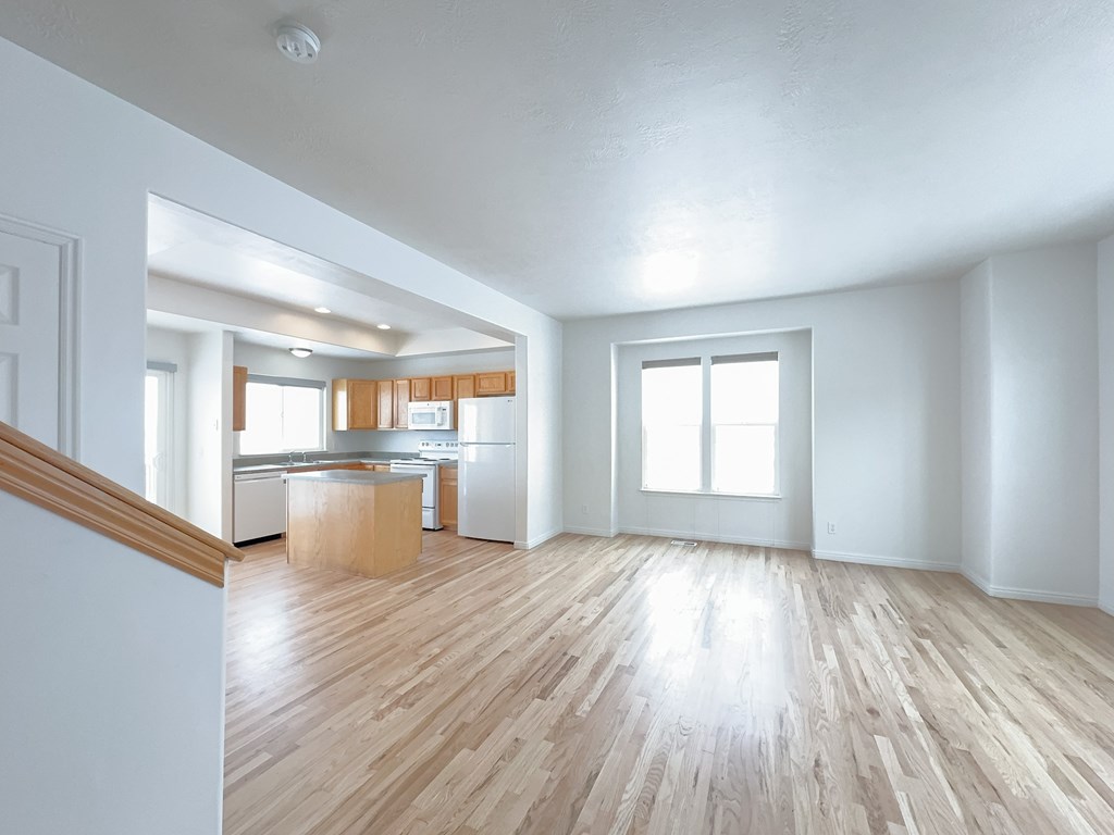 the living room and kitchen of an empty apartment