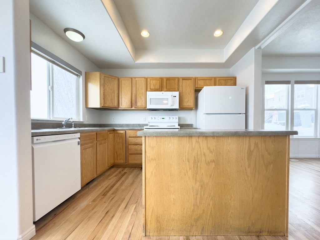 the preserve at ballantyne commons apartment kitchen with white appliances and wood cabinets
