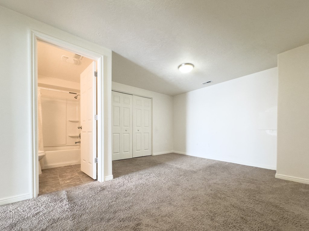 an empty living room with a door to a bathroom