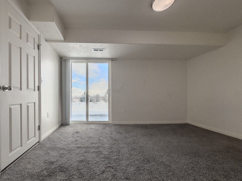 an empty living room with a door to a snowy field