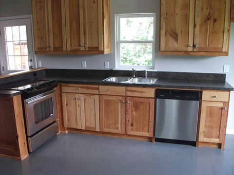 an image of a kitchen with wooden cabinets and stainless steel appliances