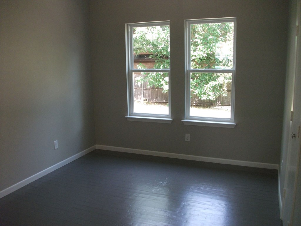 an empty room with three windows in it