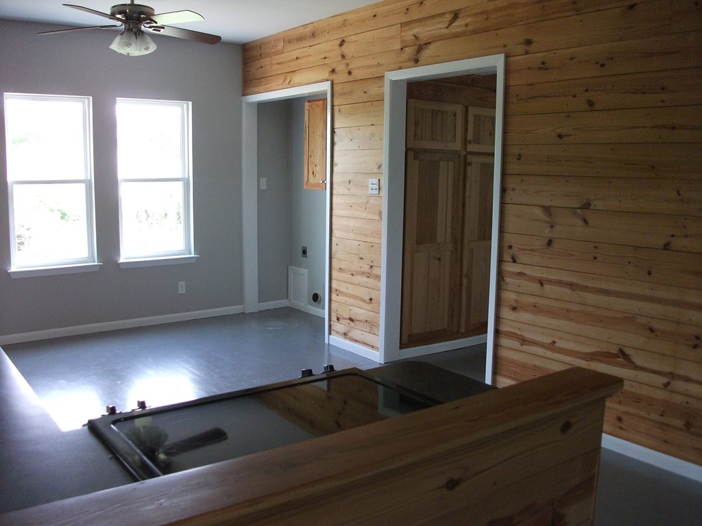 an empty living room with wood paneling on the wall