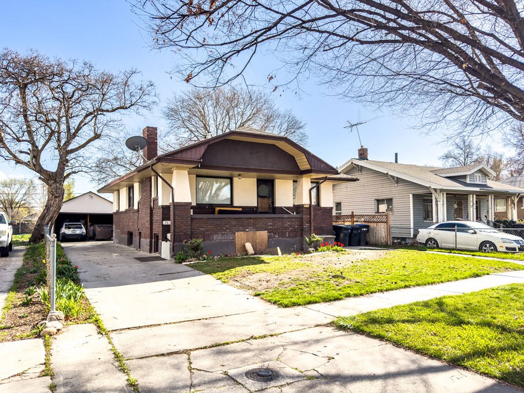 the front of a house with a yard and a sidewalk