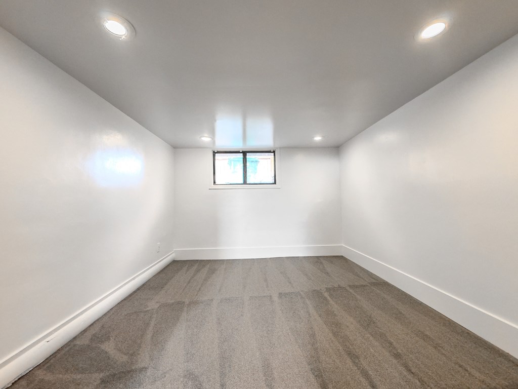 an empty room with white walls and a window
