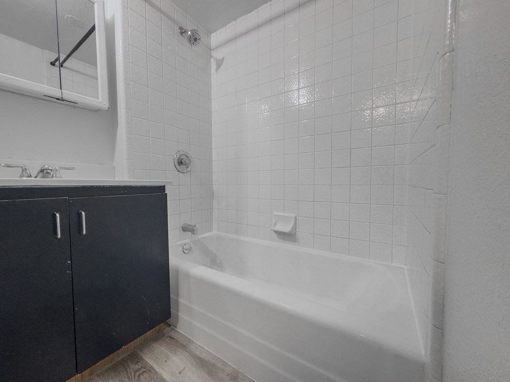 a white bathroom with a tub and a sink