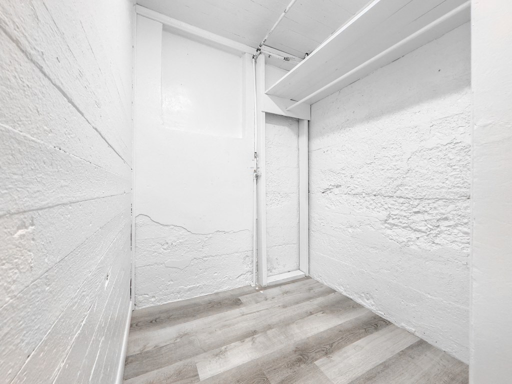 a hallway with white walls and wooden floors and a sliding glass door