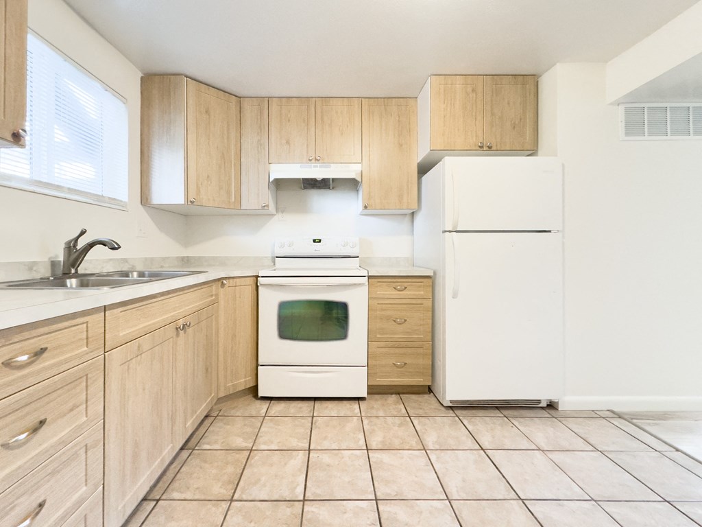 a kitchen with white appliances and wooden cabinets
