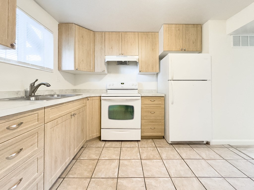 a kitchen with white appliances and wooden cabinets