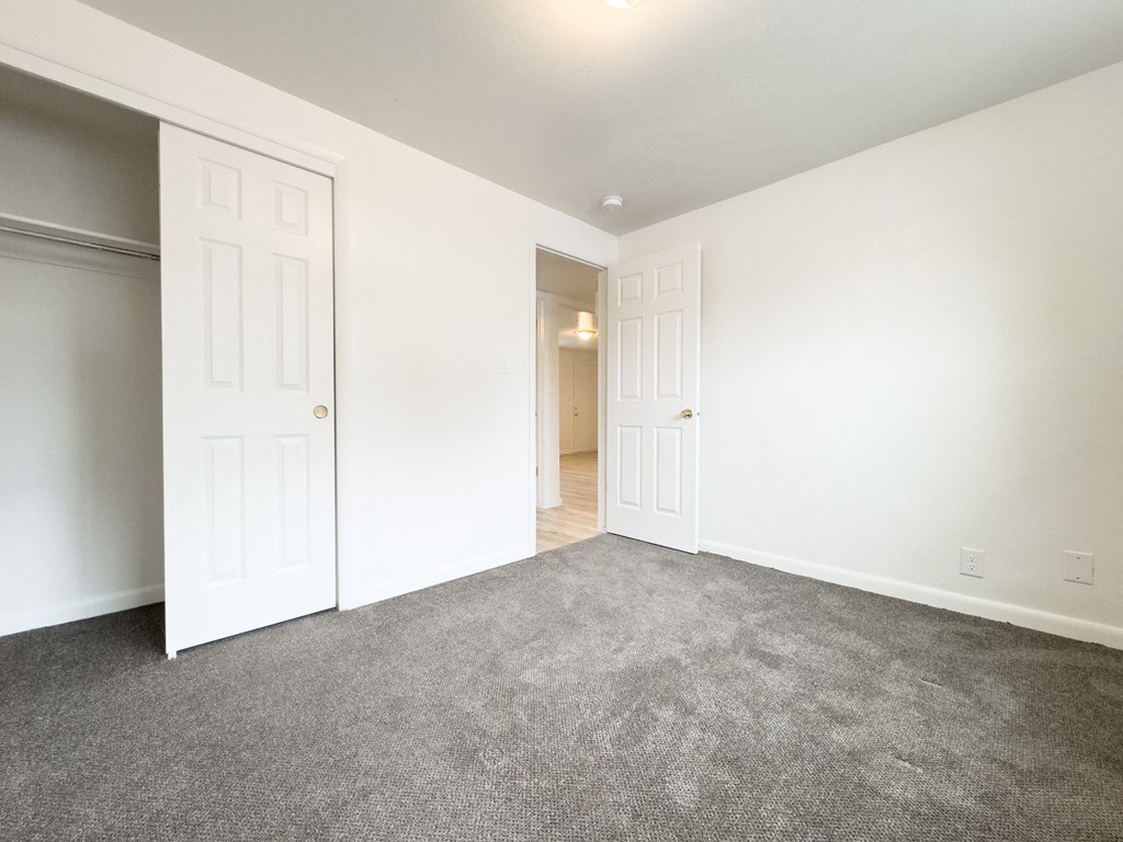 an empty living room with white walls and a carpet