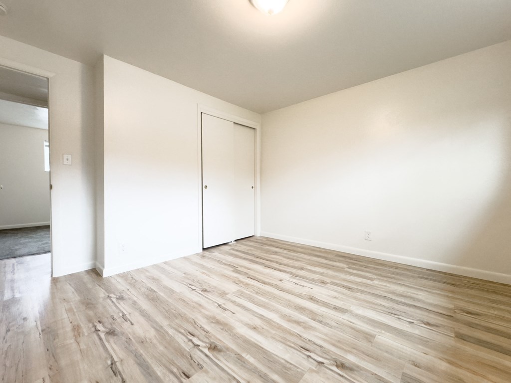 an empty living room with white walls and wood flooring