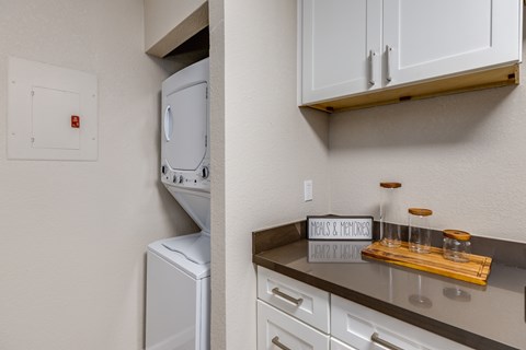 A white dishwasher is in a kitchen next to a white oven.