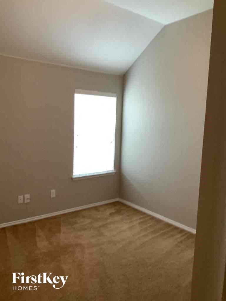 a empty room with a window and a wooden floor