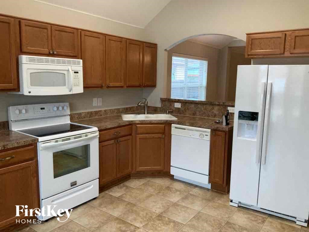 a kitchen with white appliances and wooden cabinets