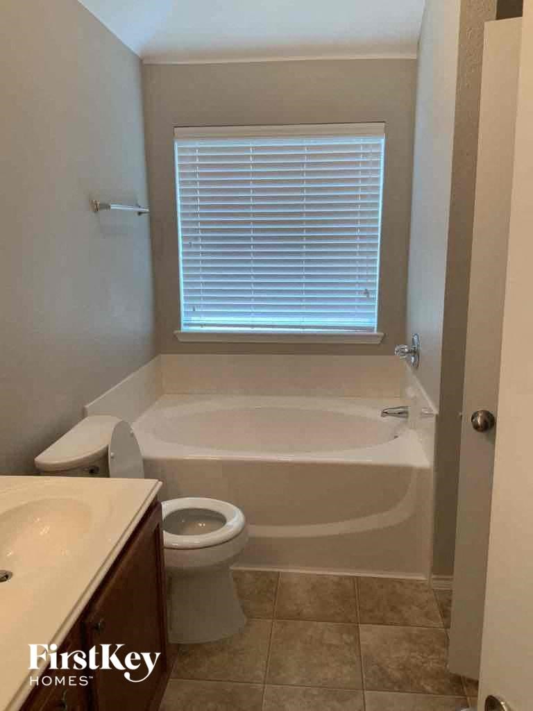 a bathroom with a toilet and a tub and a sink