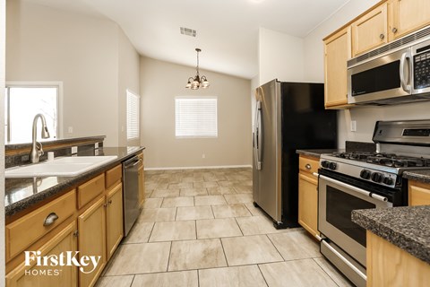 A kitchen with wooden cabinets and a black refrigerator.