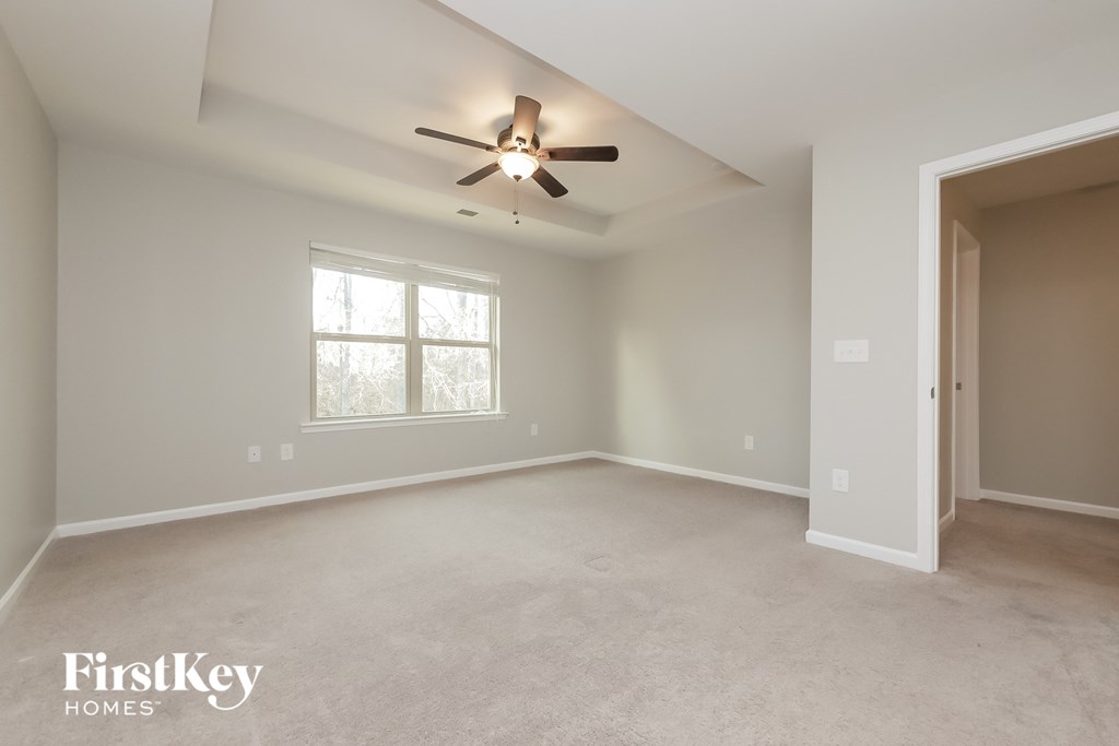 the master bedroom is spacious and has a ceiling fan