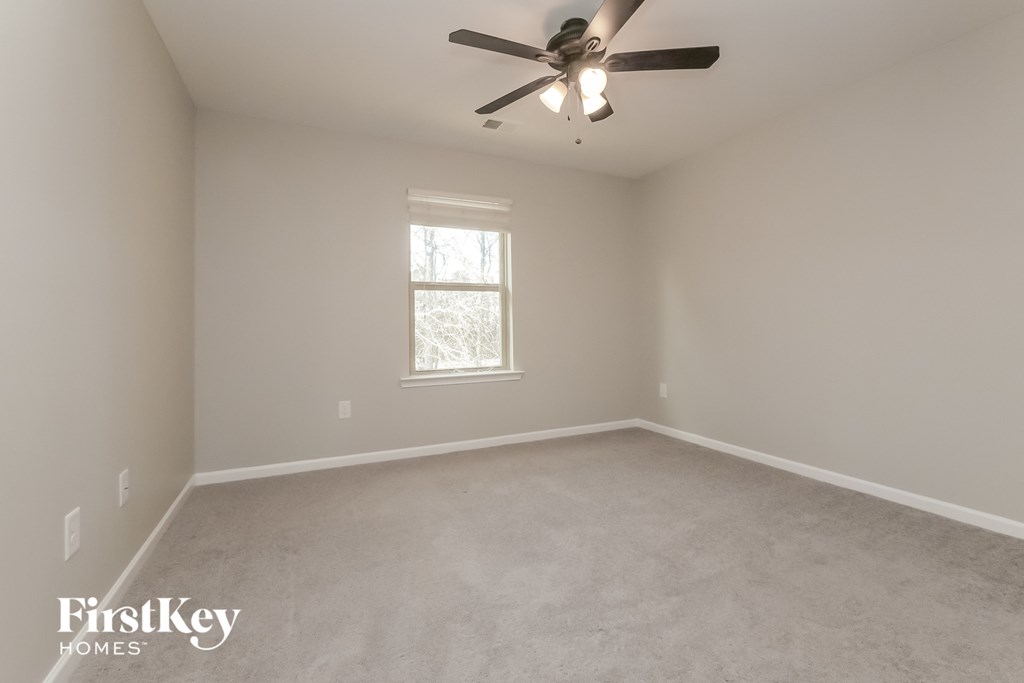 an empty room with a ceiling fan and a window