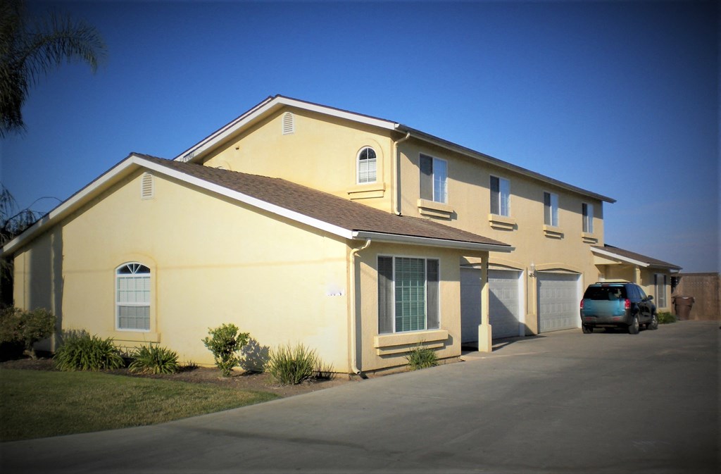 a yellow house with a car parked outside