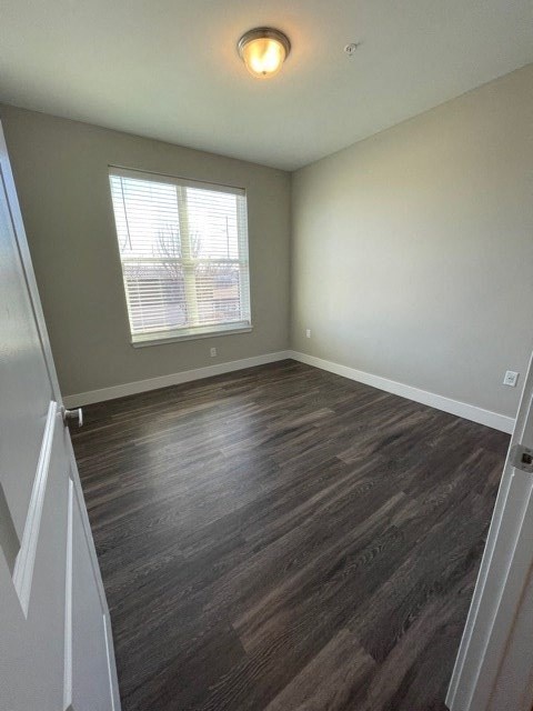 an empty room with wood floors and a window