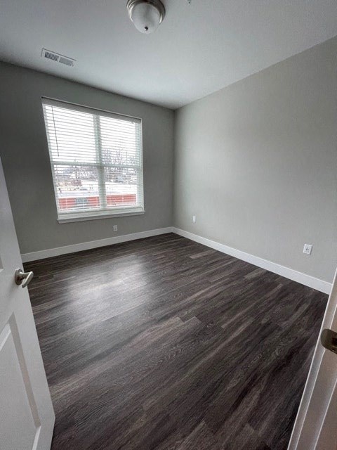 an empty room with wood floors and a window