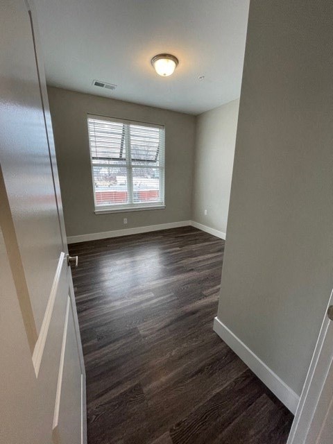 a empty room with a window and wooden floors