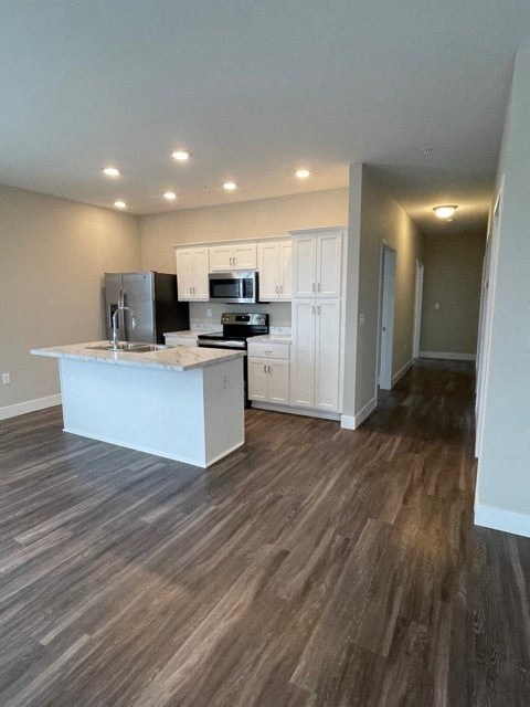 an empty kitchen with a sink and a refrigerator