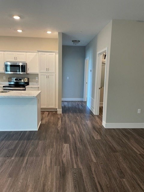 an empty kitchen with a stove and a microwave