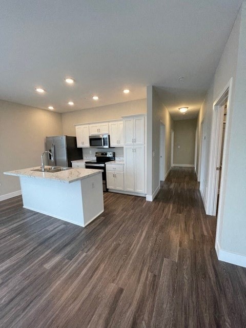 an empty kitchen with a sink and a refrigerator