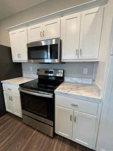 a kitchen with a stove microwave and white cabinets