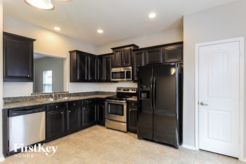 a kitchen with black cabinets and stainless steel appliances