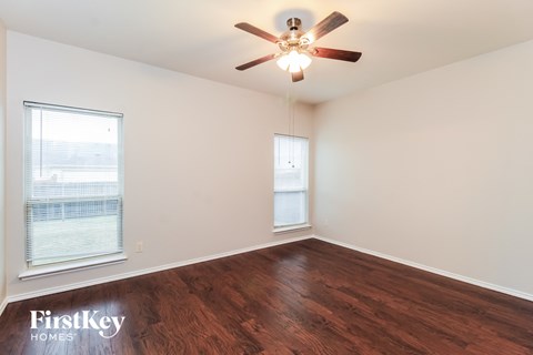 a living room with wood floors and a ceiling fan