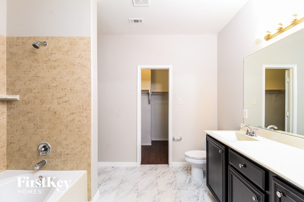 a bathroom with a shower toilet and sink and a mirror