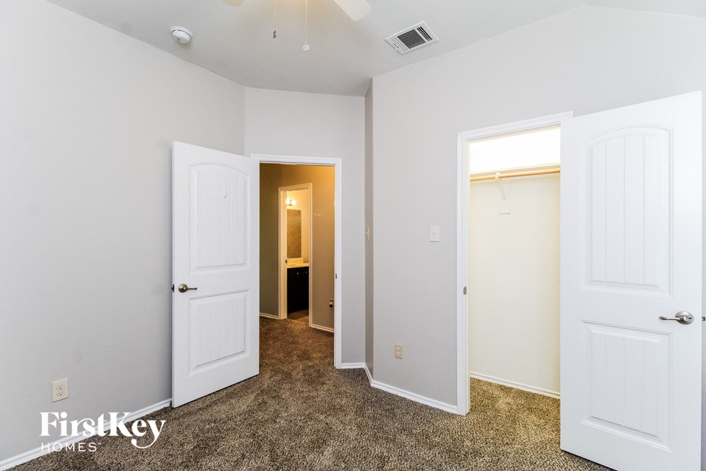 a bedroom with two closets and two doors and a bathroom