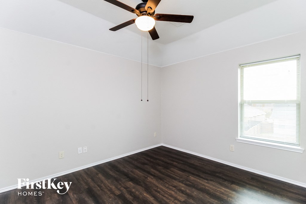 the living room of a home with wood flooring and a ceiling fan