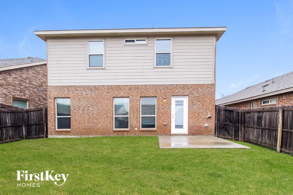a white house with a yard and a wooden fence