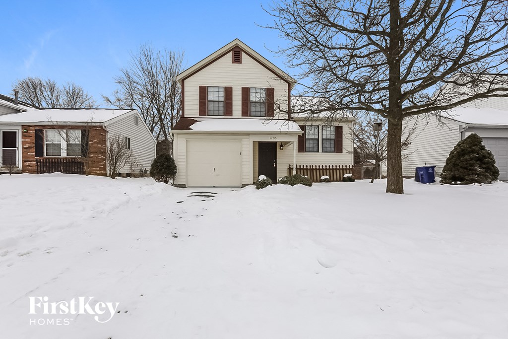 A house with a snow-covered front yard.