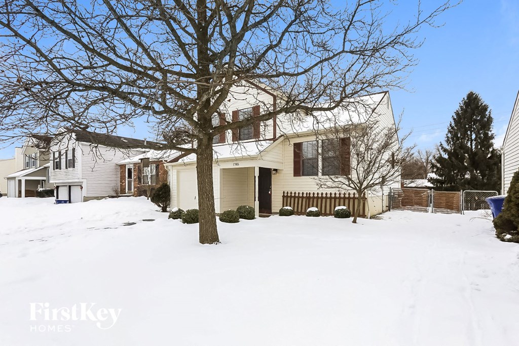 A house with a snow-covered front yard.