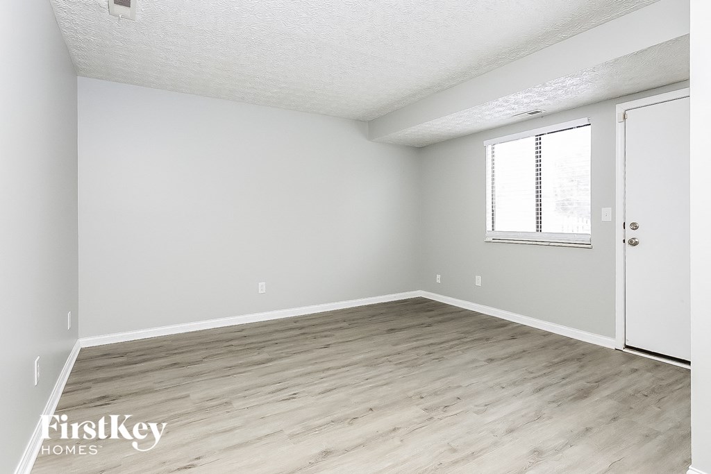 A room with a wooden floor and a white door.