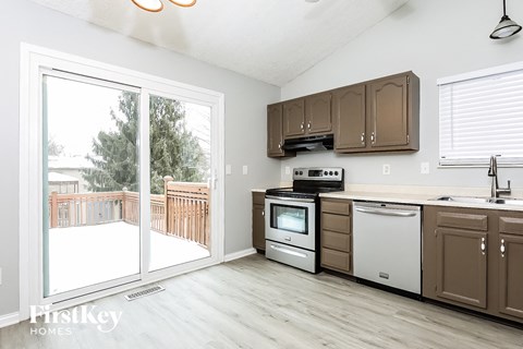 A kitchen with a white fridge, dishwasher and oven.