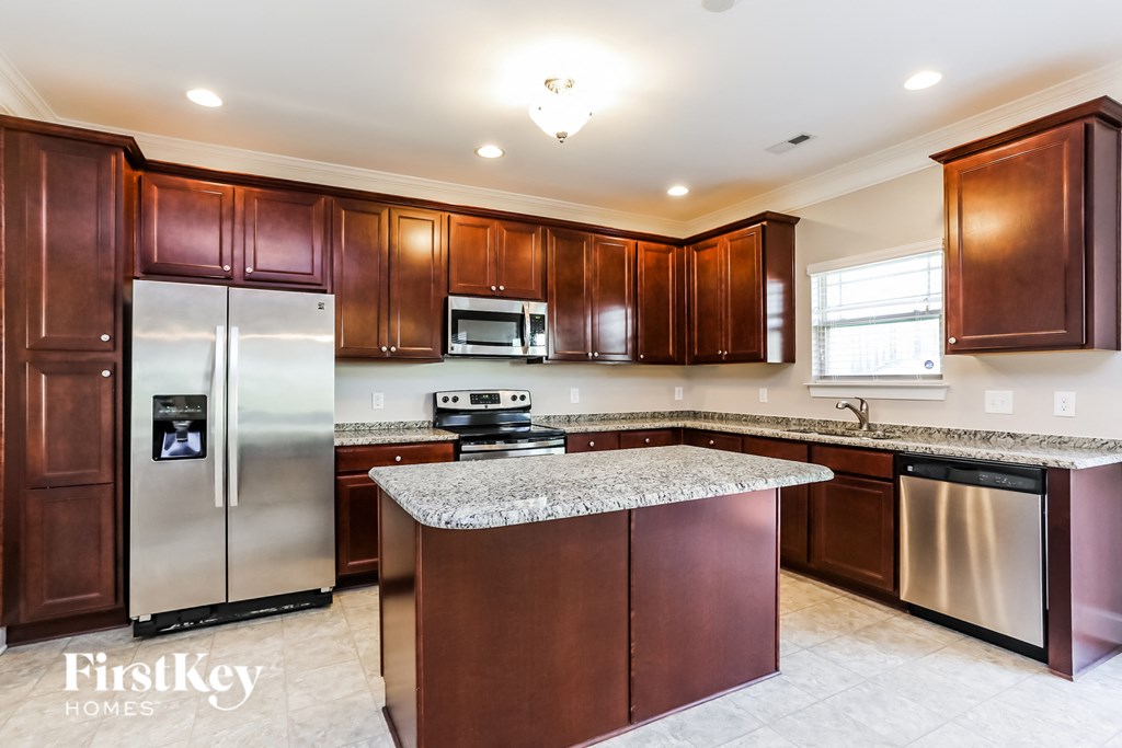 A kitchen with brown cabinets and a granite countertop.