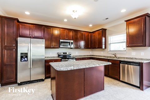 A kitchen with brown cabinets and a granite countertop.