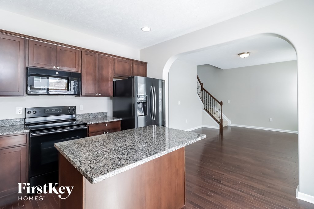 a kitchen with granite counter tops and black appliances